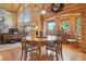 Cozy dining area features hardwood floors, a round wood table, and log walls with plenty of natural light at 3557 Palmer Ridge Dr, Parker, CO 80134