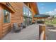 The back of this cabin home has a wooden deck area with outdoor seating and dining areas at 3557 Palmer Ridge Dr, Parker, CO 80134