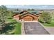 Aerial view of a log home with a green roof and long driveway nestled in a scenic, tree-filled landscape at 3557 Palmer Ridge Dr, Parker, CO 80134