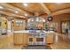 Large kitchen with a stainless steel oven range, wooden accents, and a view of the dining and living areas at 3557 Palmer Ridge Dr, Parker, CO 80134