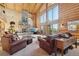 Inviting living room with a stone fireplace, log walls, large windows, and comfortable leather seating at 3557 Palmer Ridge Dr, Parker, CO 80134