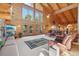 Spacious living room featuring log walls, large windows, a ceiling fan, and comfortable furnishings at 3557 Palmer Ridge Dr, Parker, CO 80134