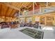 Open-concept living room featuring log beams, a high ceiling, leather furniture, and a cozy atmosphere at 3557 Palmer Ridge Dr, Parker, CO 80134