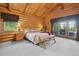 Serene primary bedroom with log walls, access to a private balcony, and comfortable furnishings at 3557 Palmer Ridge Dr, Parker, CO 80134