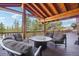 Outdoor seating area with a view of trees, comfortable furniture, and a wooden beamed ceiling at 3557 Palmer Ridge Dr, Parker, CO 80134