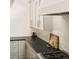 Modern kitchen featuring gray cabinets, black countertops, tile backsplash, and stainless steel appliances at 40 S Dexter St, Denver, CO 80246
