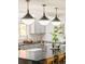 Bright kitchen with a large island, gray cabinets, gold faucet, and unique pendant lighting at 40 S Dexter St, Denver, CO 80246