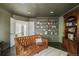 Cozy living room with a tufted leather sofa, built-in bookshelves, and access to another room at 40 S Dexter St, Denver, CO 80246