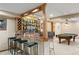 Finished basement bar area with decorative shelving, seating and billiard table at 5034 E Otero Cir, Centennial, CO 80122