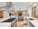 Gourmet kitchen boasts stainless appliances, large island, and opens to dining area with brick fireplace at 5034 E Otero Cir, Centennial, CO 80122