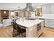 Kitchen island with cooktop and white stone countertop, complemented by hardwood floors and modern appliances at 5034 E Otero Cir, Centennial, CO 80122