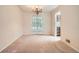 Spacious dining room with neutral carpet, a chandelier, and large double doors leading outside at 4490 Balsam St, Wheat Ridge, CO 80033