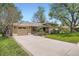 Spacious front yard with a long driveway leading to a single car garage in a charming home at 4490 Balsam St, Wheat Ridge, CO 80033