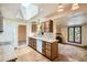 Open kitchen design with wood cabinets, skylight, and seamless flow into the dining and living areas at 4490 Balsam St, Wheat Ridge, CO 80033