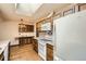 Traditional kitchen featuring wood cabinets, tile backsplash, and modern appliances under a bright skylight at 4490 Balsam St, Wheat Ridge, CO 80033