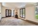 Bright living room featuring a brick fireplace, large windows, and hardwood French doors at 4490 Balsam St, Wheat Ridge, CO 80033