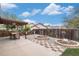Backyard with patio, dining table, chairs, mature landscaping, and garden beds at 6235 W Floyd Ave, Denver, CO 80227
