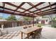 Backyard with a covered patio, dining table, chairs, gravel, and a storage shed at 6235 W Floyd Ave, Denver, CO 80227