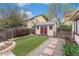 Backyard featuring artificial turf, storage shed, and mature trees at 6235 W Floyd Ave, Denver, CO 80227