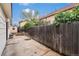 Fenced backyard with a concrete patio, storage shed, and mature landscaping at 6235 W Floyd Ave, Denver, CO 80227