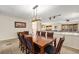 Bright dining room with a wooden table, seating for eight, and modern light fixture at 6235 W Floyd Ave, Denver, CO 80227