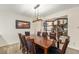 Dining room with a large wooden table, seating for eight, and modern light fixture at 6235 W Floyd Ave, Denver, CO 80227