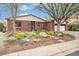 Beautiful brick home boasts a meticulously landscaped front yard with stepping stones and a lovely mature tree at 6235 W Floyd Ave, Denver, CO 80227