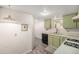 Kitchen with new vinyl flooring and neutral green cabinets at 6235 W Floyd Ave, Denver, CO 80227