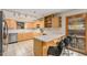 Bright kitchen with a breakfast bar, tile flooring, stainless steel appliances, and light wood cabinetry at 6235 W Floyd Ave, Denver, CO 80227