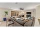 Bright living room with fireplace, large bay window, plush gray sectional and neutral carpet at 6235 W Floyd Ave, Denver, CO 80227