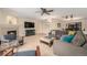 Comfortable living room featuring a cozy fireplace, plush seating, a ceiling fan and neutral carpet at 6235 W Floyd Ave, Denver, CO 80227