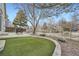 Inviting backyard with artificial turf, stone details, patio, and mature trees, creating a peaceful outdoor living space at 6508 Moss Cir, Arvada, CO 80007