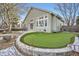 Charming backyard featuring a putting green, stone border, patio, and well-maintained exterior of the home at 6508 Moss Cir, Arvada, CO 80007