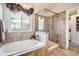 Elegant bathroom featuring a soaking tub, glass enclosed shower, and updated fixtures at 6508 Moss Cir, Arvada, CO 80007