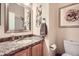 Cozy bathroom with granite countertop, framed mirror, and decorative artwork at 6508 Moss Cir, Arvada, CO 80007