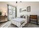 Inviting bedroom featuring a large window providing natural light, wood furniture and neutral décor at 6508 Moss Cir, Arvada, CO 80007