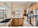 Modern kitchen featuring stainless appliances, granite counters and large windows offering natural light at 6508 Moss Cir, Arvada, CO 80007