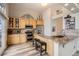 Well-lit kitchen featuring granite counters, stainless steel appliances, hardwood floors and breakfast bar at 6508 Moss Cir, Arvada, CO 80007