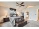 Comfortable bedroom featuring a ceiling fan, large windows, carpet and a decorative bench at 6508 Moss Cir, Arvada, CO 80007