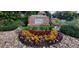 Attractive community entrance sign surrounded by colorful flowerbeds, lush greenery, and decorative rocks at 6508 Moss Cir, Arvada, CO 80007