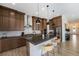 Bright kitchen featuring a center island with barstool seating, dark wood cabinets, and stainless steel appliances at 7202 Canyonpoint Rd, Castle Pines, CO 80108