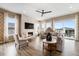 Cozy living room with ample seating, fireplace with a light marble mantle, large windows, and a ceiling fan at 7202 Canyonpoint Rd, Castle Pines, CO 80108