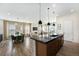 Open concept living space featuring a kitchen island, dining area, living room with fireplace, and abundant natural light at 7202 Canyonpoint Rd, Castle Pines, CO 80108