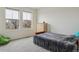 Minimalist bedroom featuring two windows, a gray bed, and a comfortable beanbag chair at 18108 E 52Nd Ave, Denver, CO 80249