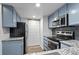 Galley kitchen with granite countertops and stainless steel appliances at 7820 W 87Th Dr # K, Arvada, CO 80005