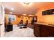 Finished basement bar area with custom granite countertop, custom cabinetry, and nearby media room at 3902 Eagle Tail Ln, Castle Rock, CO 80104