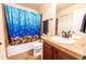 bathroom featuring ocean-themed shower curtain, neutral tile and dark wood cabinets at 3902 Eagle Tail Ln, Castle Rock, CO 80104