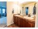 Bathroom vanity with double sinks, wood cabinets, and tile countertop at 3902 Eagle Tail Ln, Castle Rock, CO 80104