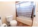 Bathroom with a toilet, tub and shower featuring a striped shower curtain, and tiled walls for a clean and modern look at 3902 Eagle Tail Ln, Castle Rock, CO 80104