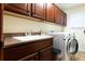 Laundry room with modern washer and dryer, utility sink, and ample cabinet space, designed for convenience at 3902 Eagle Tail Ln, Castle Rock, CO 80104